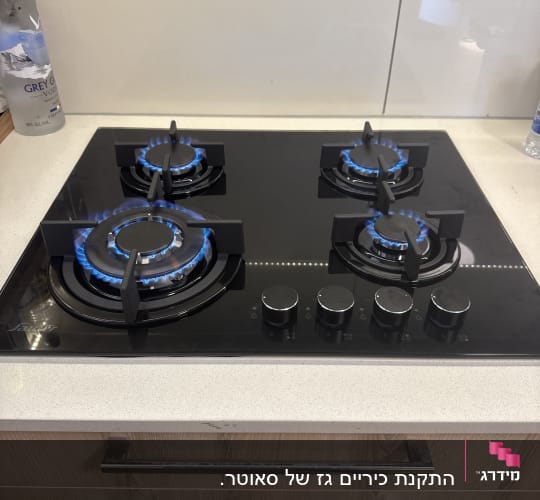 כיריים גז עם להבות כחולות במטבח מודרני